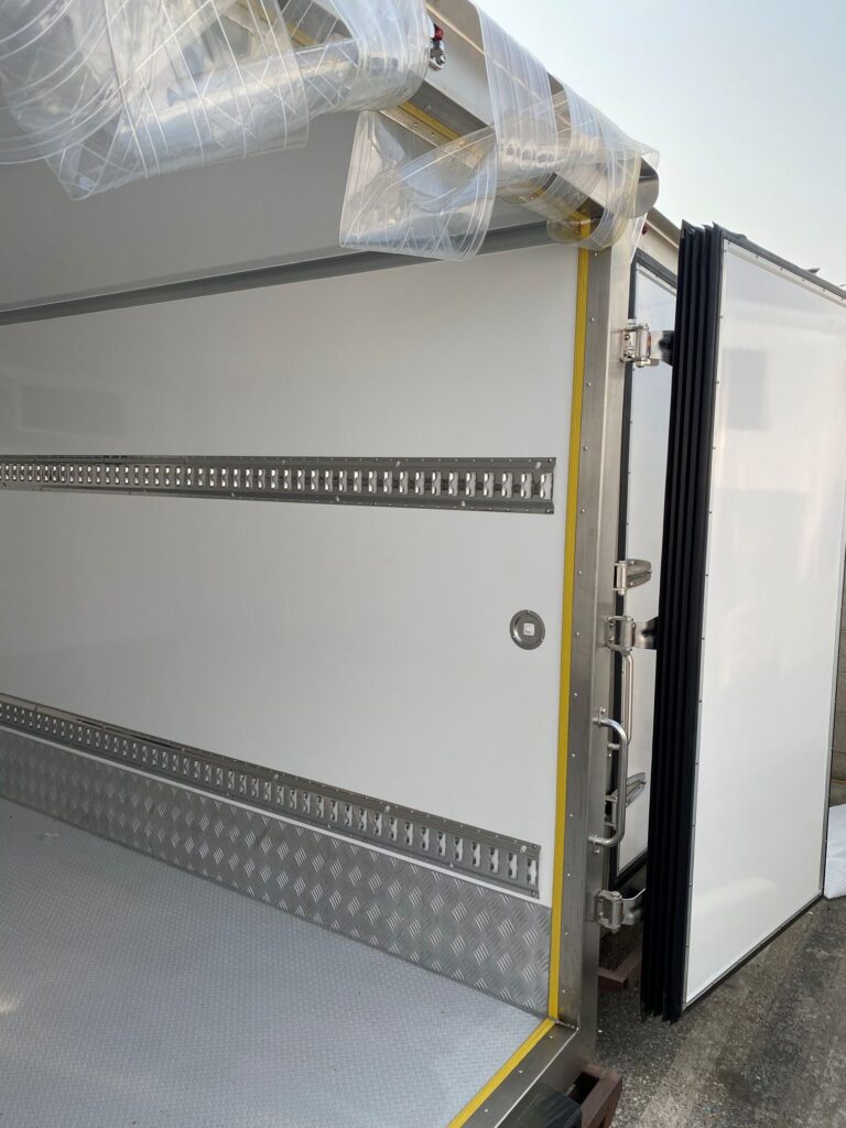 Rear of 2026 NEW Govi 7′ x 16′ Seamless trailer with rear doors open, plastic insulation flaps pulled aside showing interior of trailer right side.